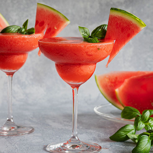 Glass of zero alcohol frozen rose cocktail with a slice of watermelon to garnish