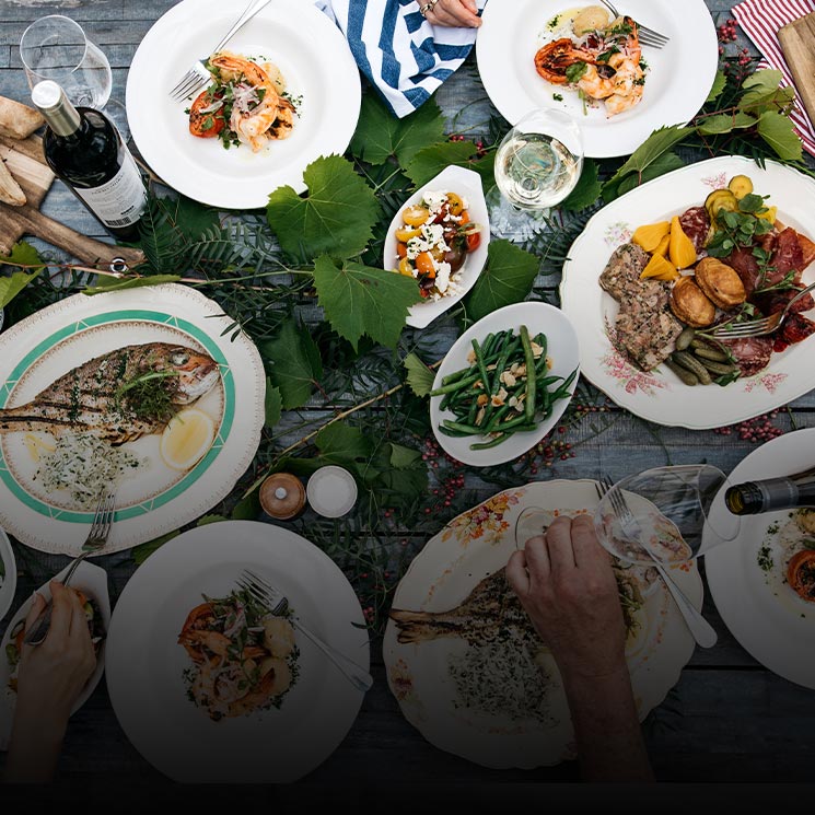 Beans, salad, meat, cheese, wine and assorted foods spread across a table